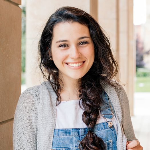 Cute student girl with braid smiling at you